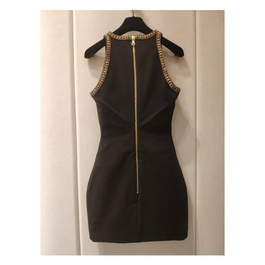 Black sleeveless mini dress with intricate gold sequins and fringe embellishments, styled for a glamorous evening look
