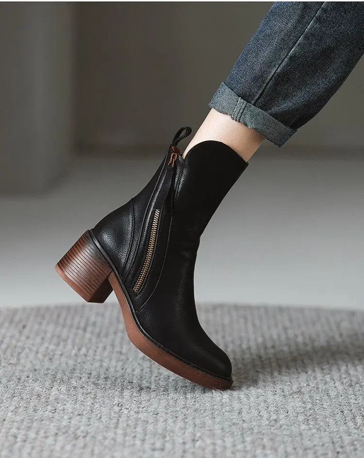 Black ankle boot with brown heel on a neutral background