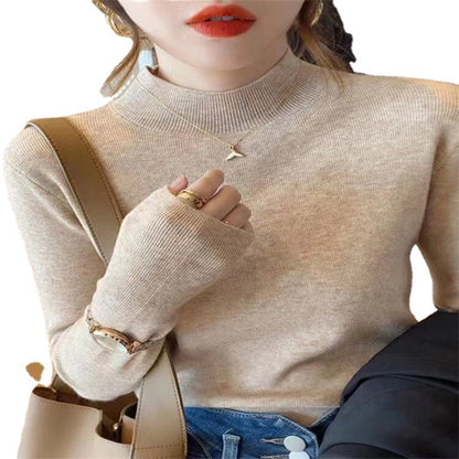 Woman wearing a ribbed light-colored turtleneck sweater, accessorized with hoop earrings, a delicate necklace, and rings—cozy, elegant, and perfect for chilly days.