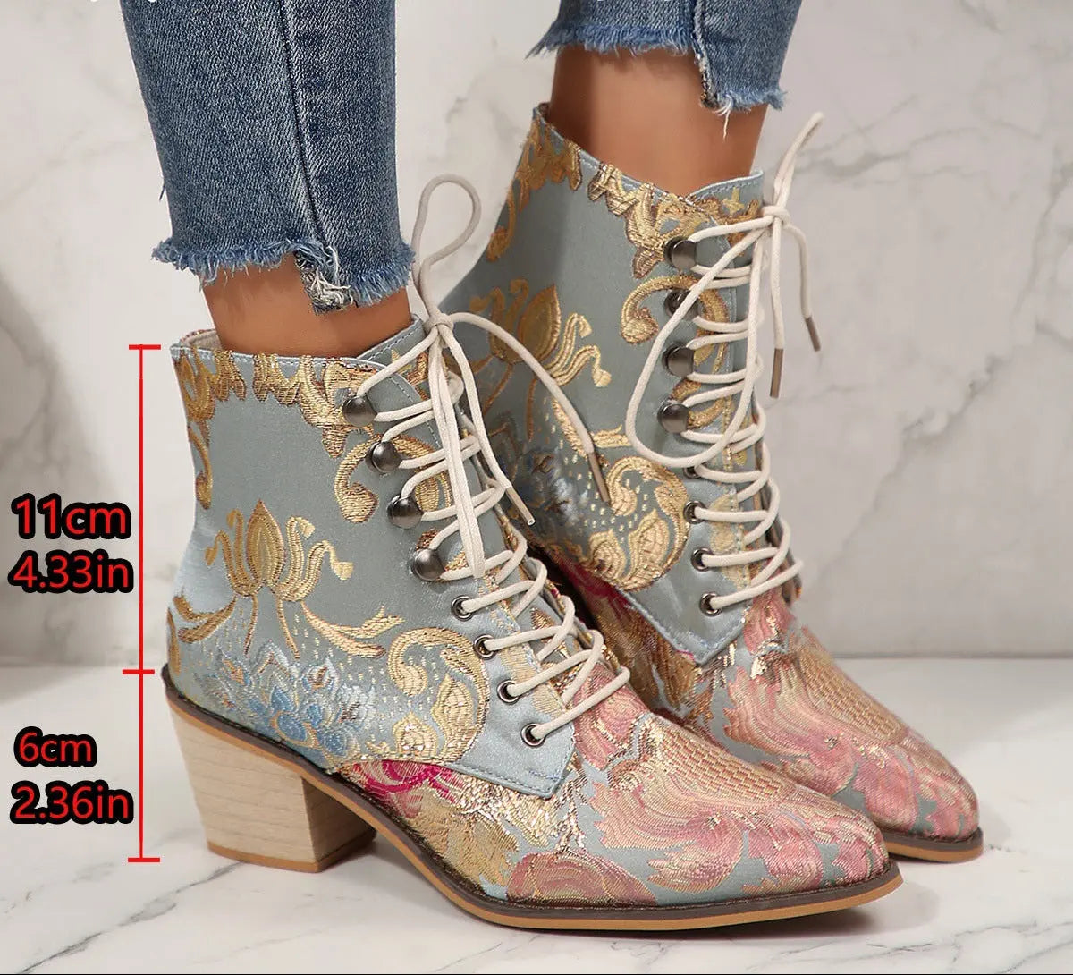 A pair of lace-up ankle boots with a light blue base and ornate gold, pink, and blue brocade-style pattern, shown on a person's feet with jeans. Red text on the image indicates boot heights of 11 cm and 6 cm.