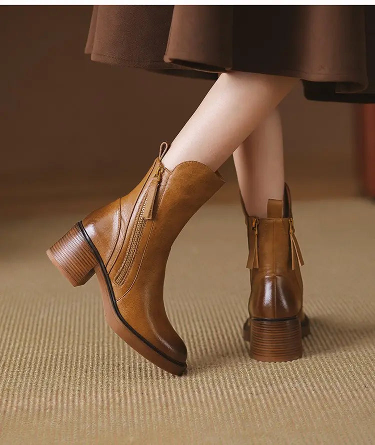 Brown leather boots worn with a brown skirt on a textured surface