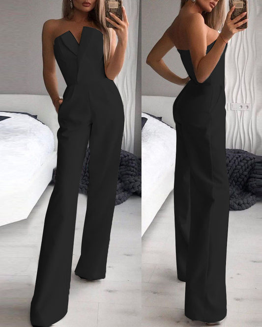Stylish woman in a chic black strapless jumpsuit taking a mirror selfie, showcasing a sleek V-neckline and wide-leg silhouette—effortlessly elegant and modern.