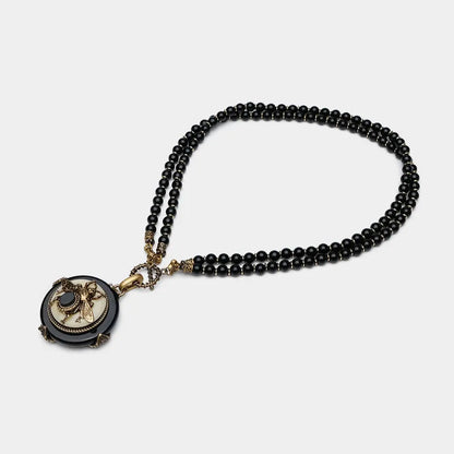 Vintage bee pendant necklace with natural black agate beads and antique copper detailing.