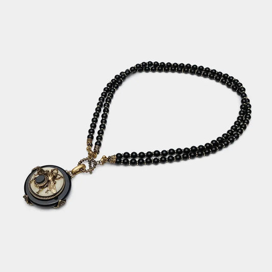 Vintage bee pendant necklace with natural black agate beads and antique copper detailing.