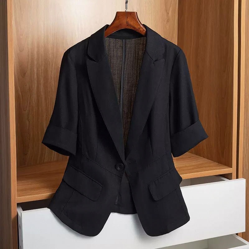 Black tailored blazer with a single-button closure, structured shoulders, front flap pockets, and rolled-up sleeves—modern, elegant, and perfect for office or casual styling.