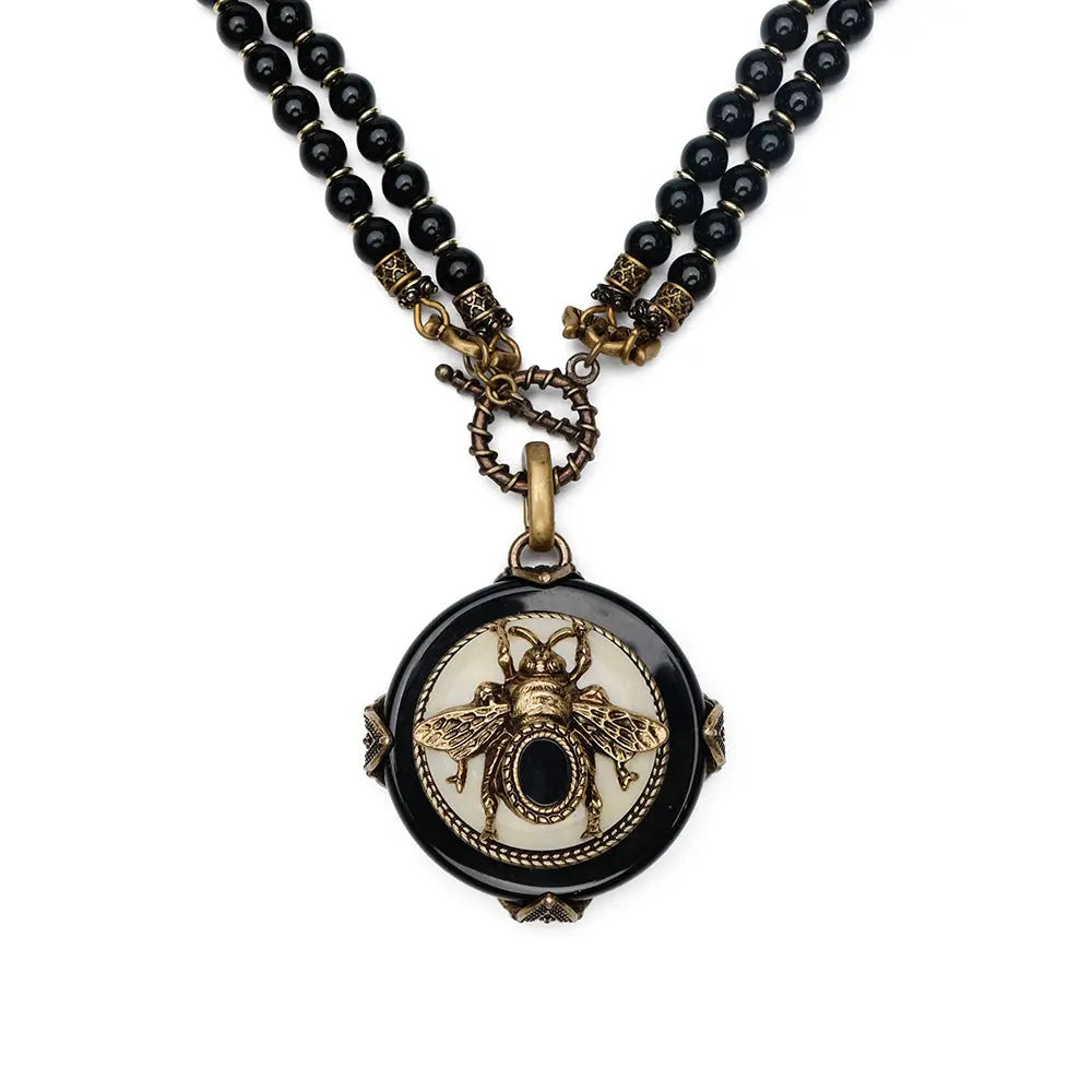 Vintage bee pendant necklace with natural black agate beads and antique copper detailing.