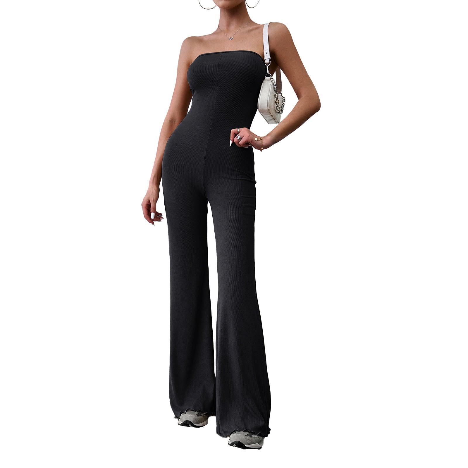 Elegant strapless jumpsuit available in beige, blue, brown, light beige, and black – form-fitting with a flared bottom, paired with sneakers and a white handbag.