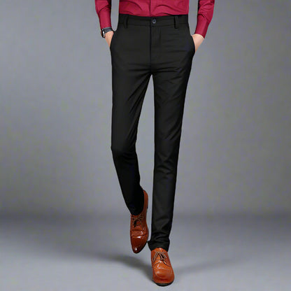 Multiple views of structured tailored trousers in navy, grey, black, and additional colours, styled with a white shirt and brown shoes, highlighting pleats, tapered legs, and buttoned back pockets
