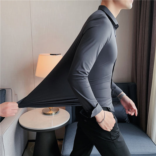Premium stretch silk men’s long-sleeve button-up shirt in a solid white color, worn by a seated individual, showcasing smooth luxurious fabric and business-ready styling.
