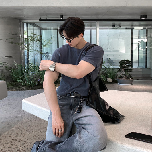 A stylish man wearing premium short sleeve t-shirts in charcoal gray, black, and forest green, highlighting the modern fit and versatile design.