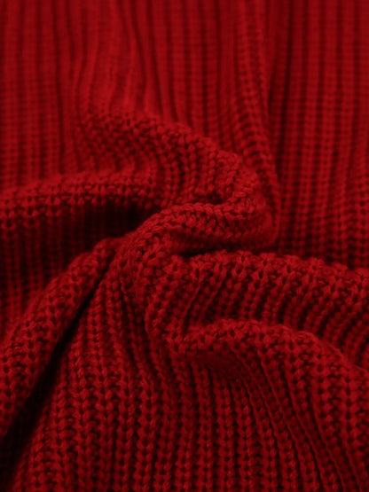 A close-up of a deep red ribbed knit fabric, showing the detailed texture and folds of the material.
