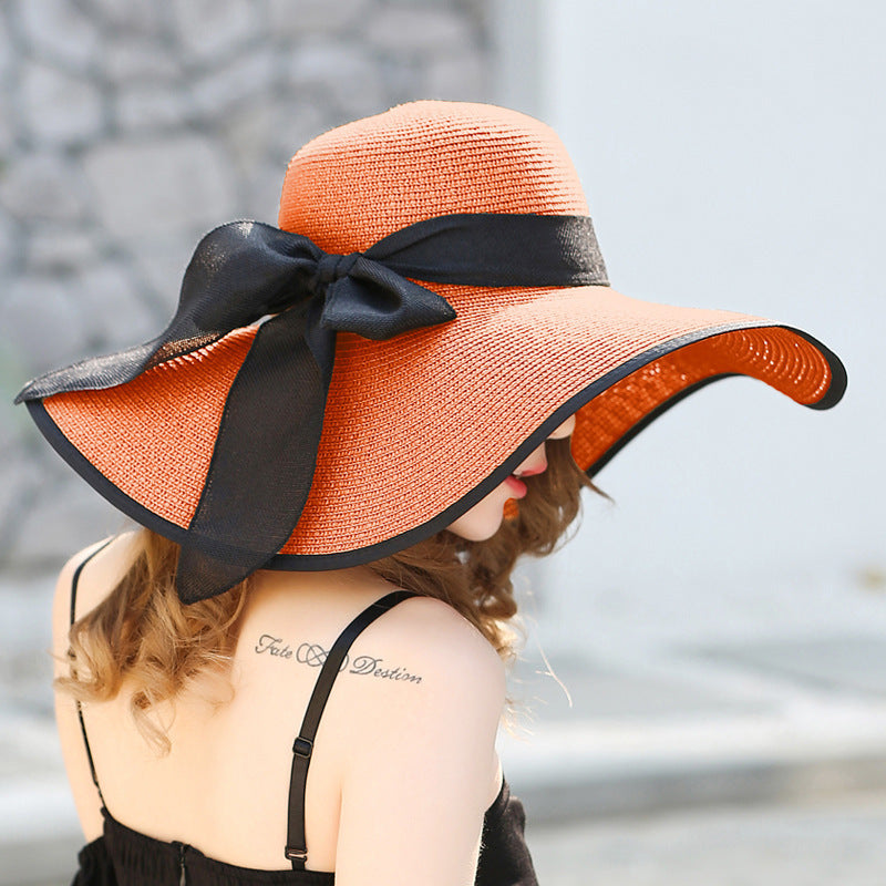 Elegant wide-brim sun hat with a bow detail, available in multiple colors including beige, black, white, pink, and blue—stylish, lightweight, and perfect for sunny days.