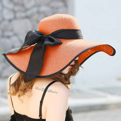 Elegant wide-brim sun hat with a bow detail, available in multiple colors including beige, black, white, pink, and blue—stylish, lightweight, and perfect for sunny days.