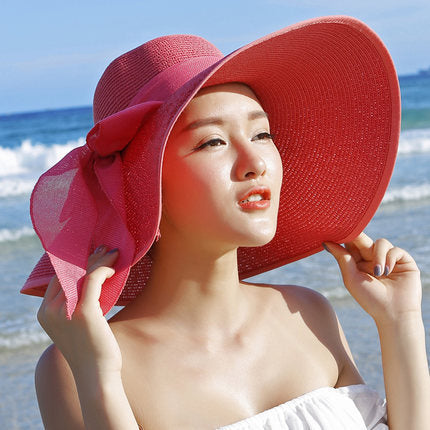 Elegant wide-brim sun hat with a bow detail, available in multiple colors including beige, black, white, pink, and blue—stylish, lightweight, and perfect for sunny days.