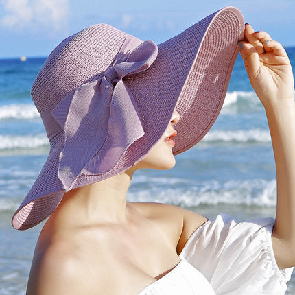 Elegant wide-brim sun hat with a bow detail, available in multiple colors including beige, black, white, pink, and blue—stylish, lightweight, and perfect for sunny days.