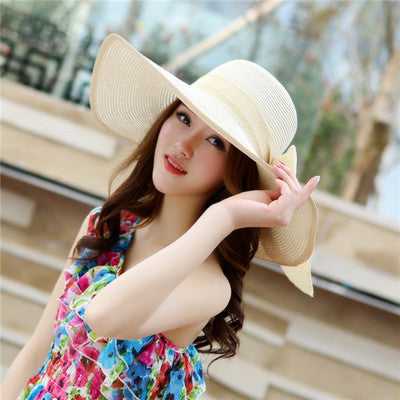Elegant wide-brim sun hat with a bow detail, available in multiple colors including beige, black, white, pink, and blue—stylish, lightweight, and perfect for sunny days.
