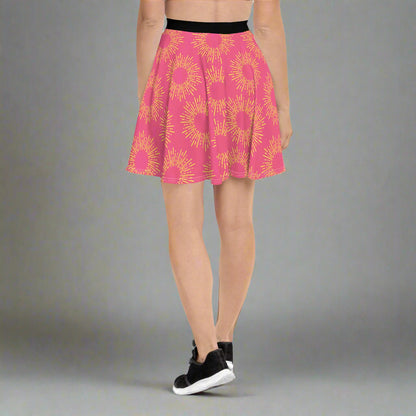 Pink skirt featuring a striking yellow sunburst pattern, paired with a black waistband and athletic shoes—bold, vibrant, and perfect for making a statement.