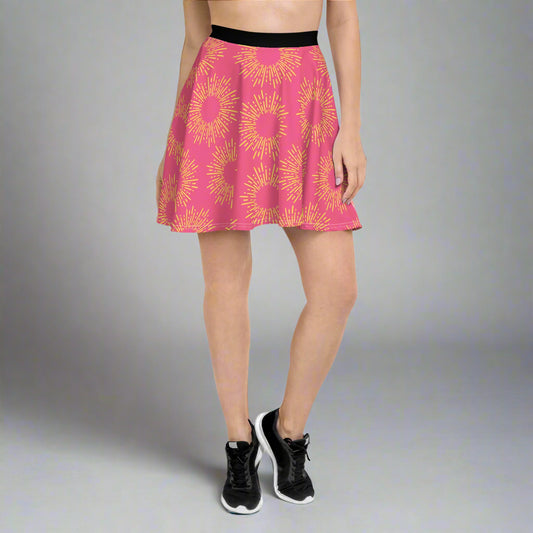 Pink skirt featuring a striking yellow sunburst pattern, paired with a black waistband and athletic shoes—bold, vibrant, and perfect for making a statement.