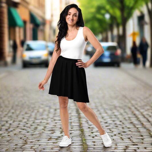 Person wearing a white sleeveless top paired with a black flared skirt and white sneakers—stylish, versatile, and perfect for casual chic wear.