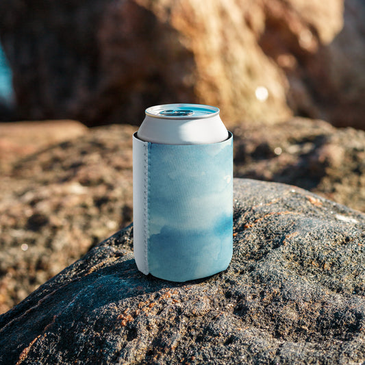 Can wrapped in a blue and white sleeve with stitched seam, placed on a rock—sleek, insulated, and perfect for casual drink accessories.