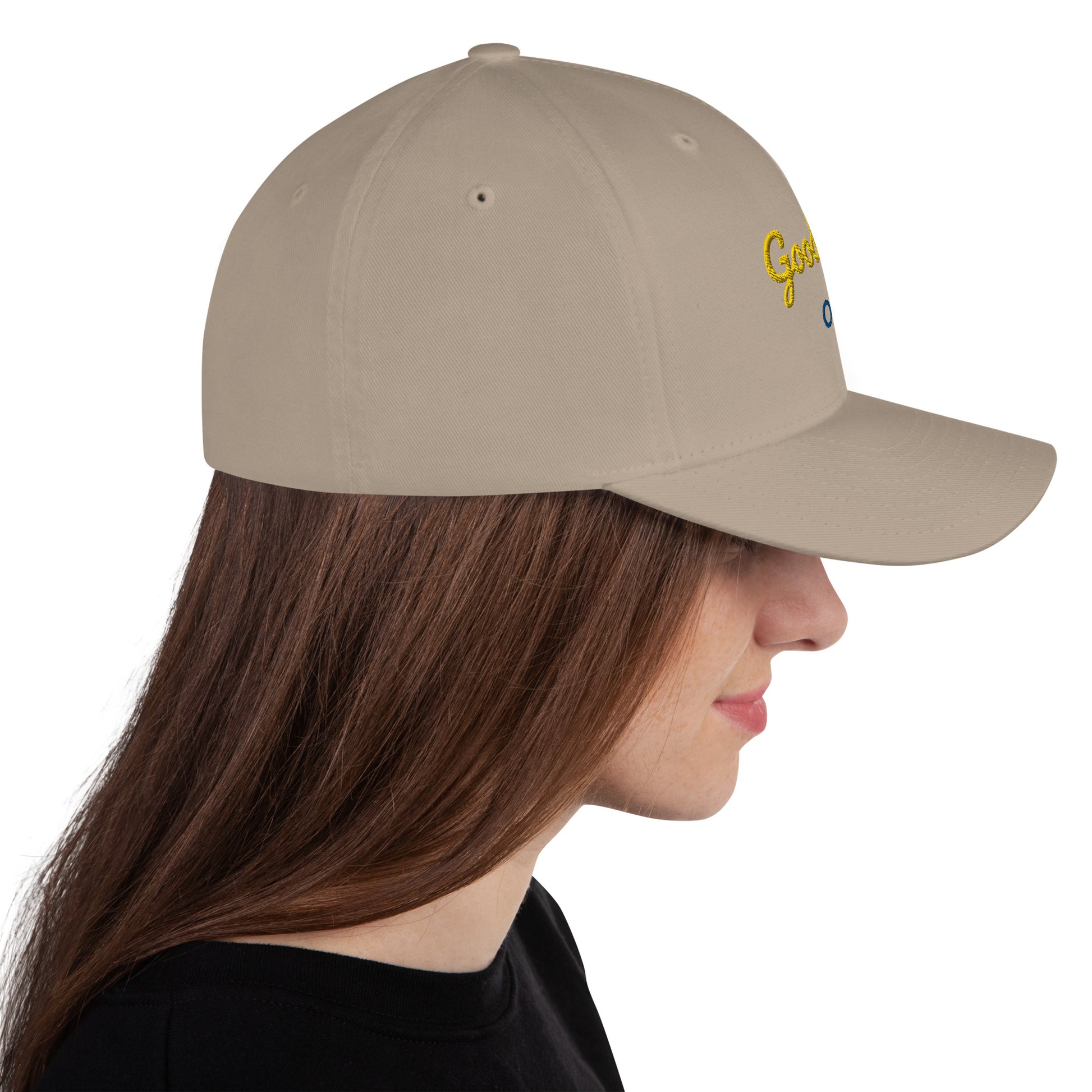 White baseball cap featuring embroidered text reading ‘GOOD VIBES ONLY’ in yellow, placed beside black headphones and stationery—modern, stylish, and perfect for casual wear.