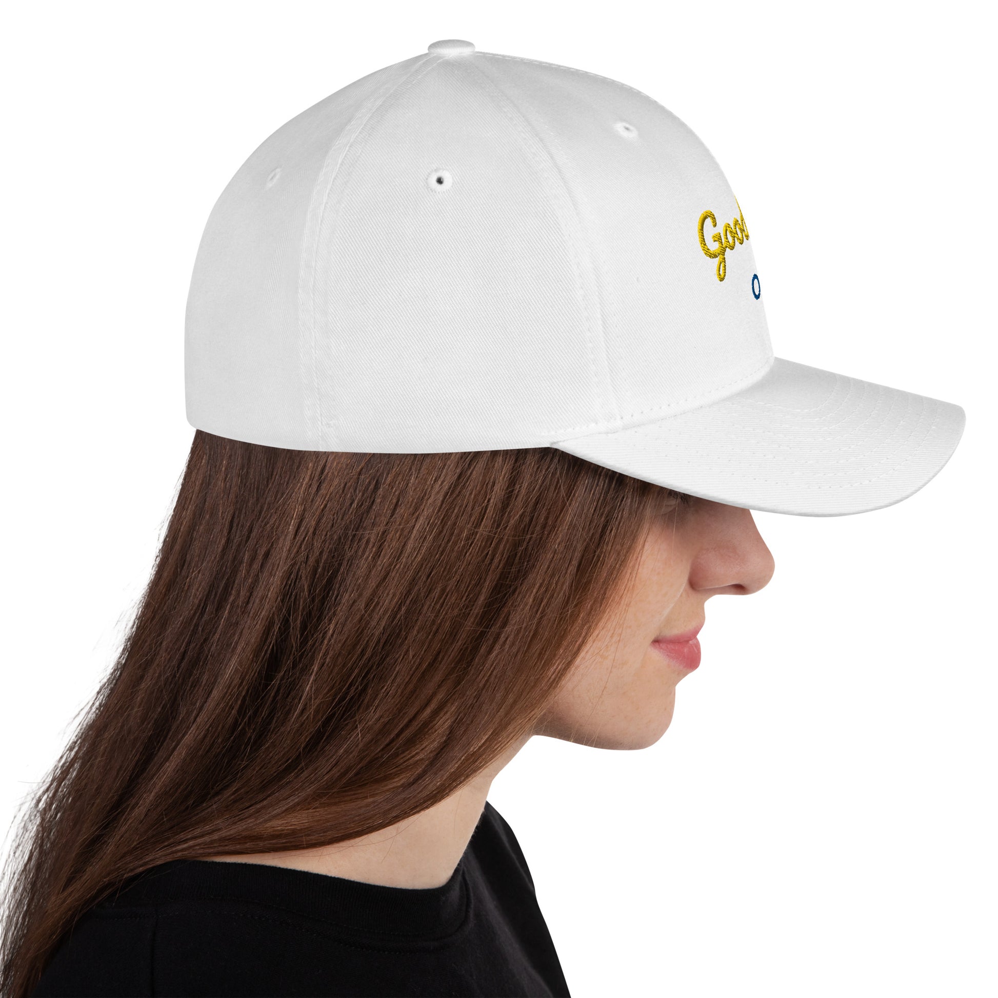 White baseball cap featuring embroidered text reading ‘GOOD VIBES ONLY’ in yellow, placed beside black headphones and stationery—modern, stylish, and perfect for casual wear.
