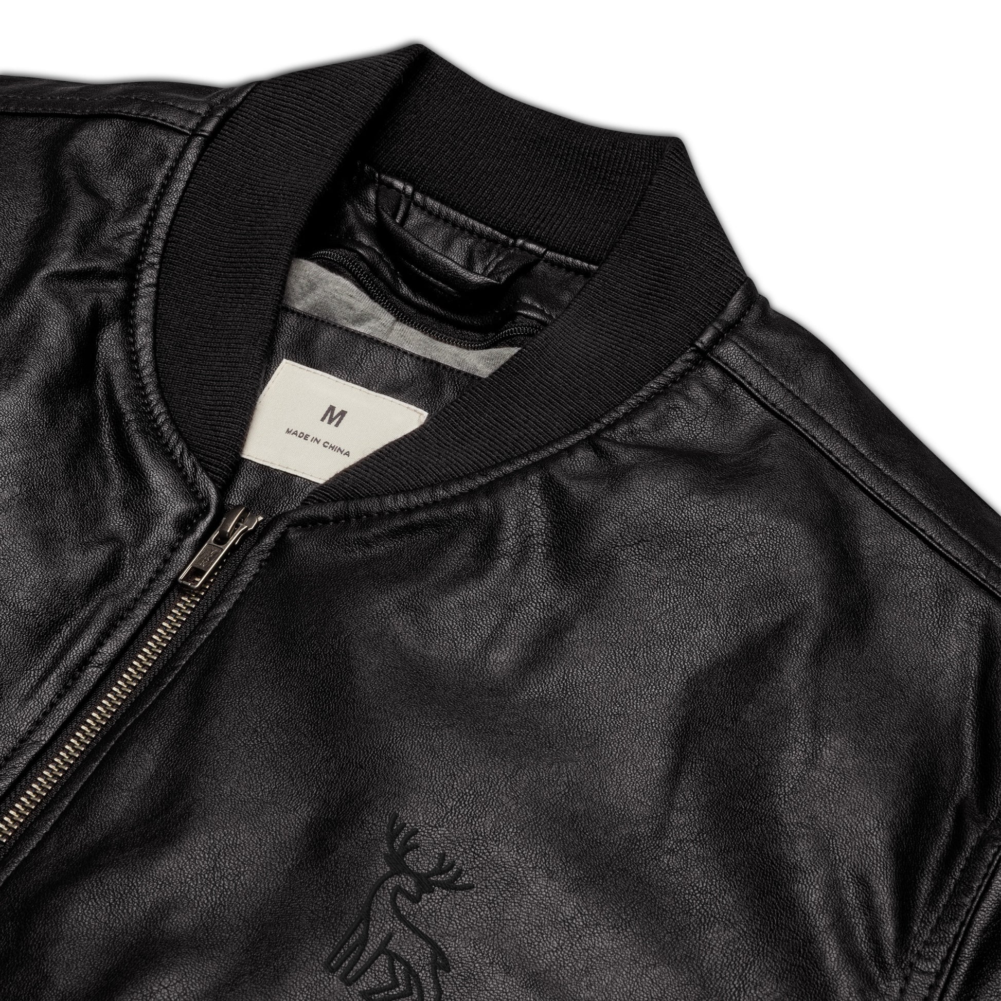 Black faux leather jacket with ribbed cuffs and hem, a zip-up front, soft grey inner lining, and a small embroidered deer logo on the chest—stylish, structured, and perfect for casual or dressy outfits.