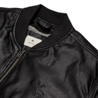 Black faux leather jacket with ribbed cuffs and hem, a zip-up front, soft grey inner lining, and a small embroidered deer logo on the chest—stylish, structured, and perfect for casual or dressy outfits.