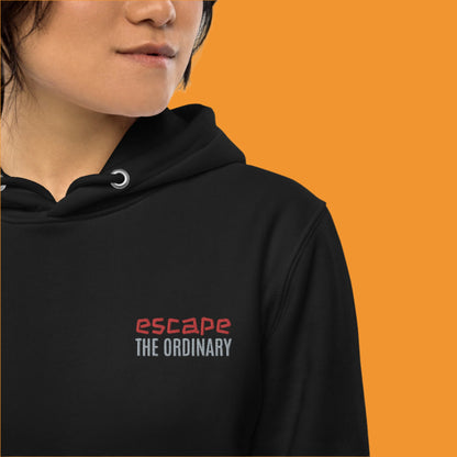 Minimalist street-style hoodie available in navy blue, black, and white, featuring a bold text design on the chest reading ‘escape’ in red and ‘THE ORDINARY’ in white, along with a front pocket and adjustable metal-tipped drawstring hood.