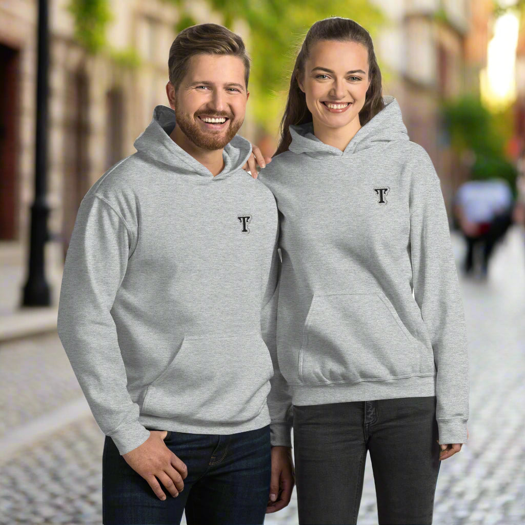 Two people wearing grey hoodies featuring an embroidered letter ‘T’ on the left chest, standing close together with arms around each other—modern, stylish, and available in black, white, and navy blue.