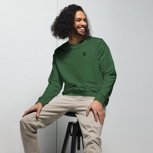 Green sweatshirt featuring an embroidered letter ‘T’ on the left chest, worn with beige pants, seated on a black stool against a white background—modern, stylish, and available in multiple colors.