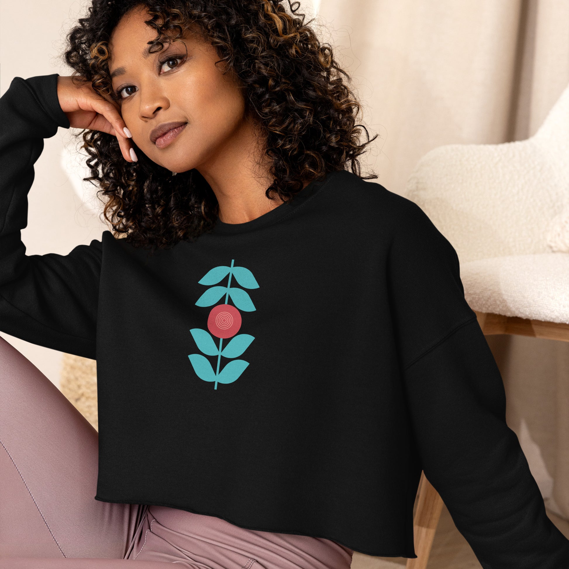 Black sweatshirt featuring a bold stylized floral graphic with blue leaves and a red circular center—modern, artistic, and perfect for casual wear.